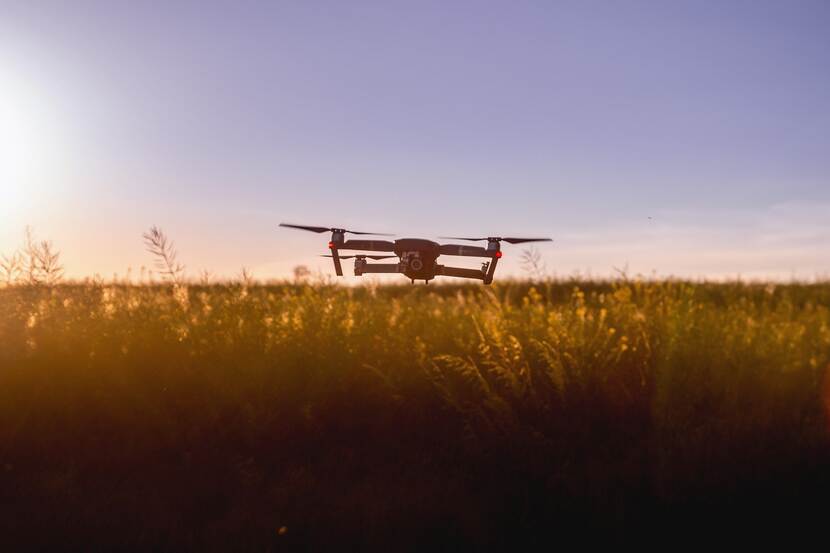 Picture of a drone hovering over a field.