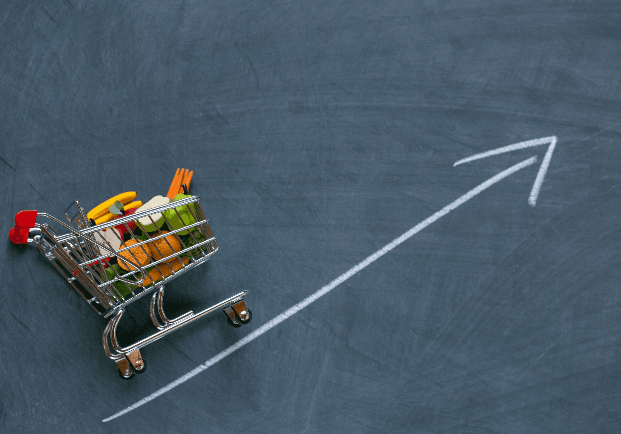 Winkelwagentje met voeding volgt een pijl die naar rechtsboven wijst. Dit illustreert de stijgende voedselprijzen.
