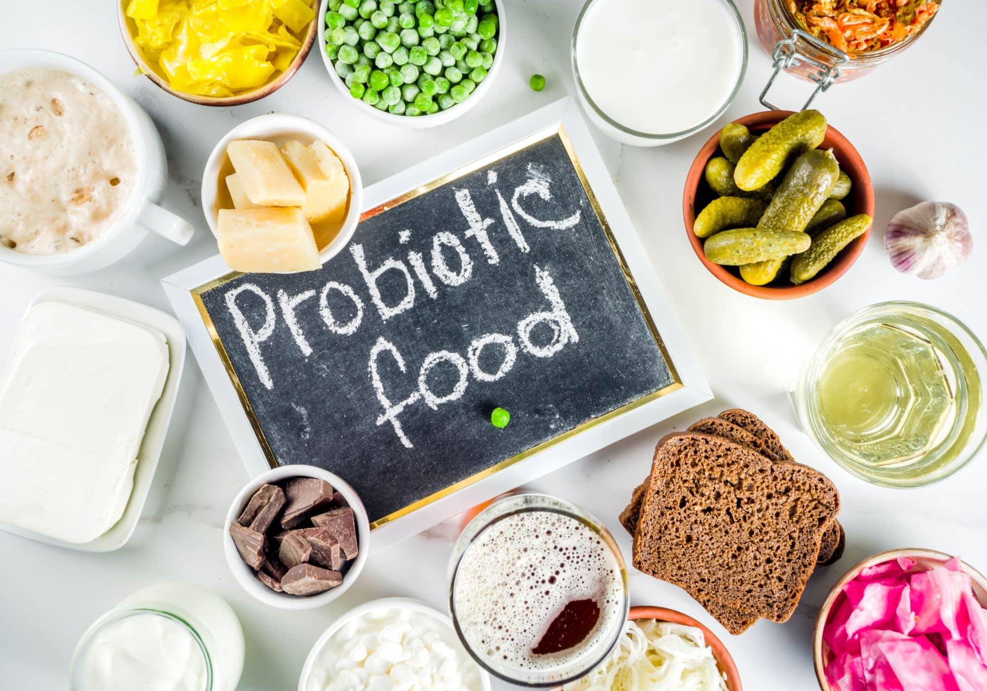 verschillende voedingsproducten die probiotica bevatten liggen op een tafel rond een bord met daarom probiotica geschreven