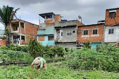 Medewerker 'Hortas Cariocas' aan het werk in de stadstuin in Manguinhos, Rio de Janeiro