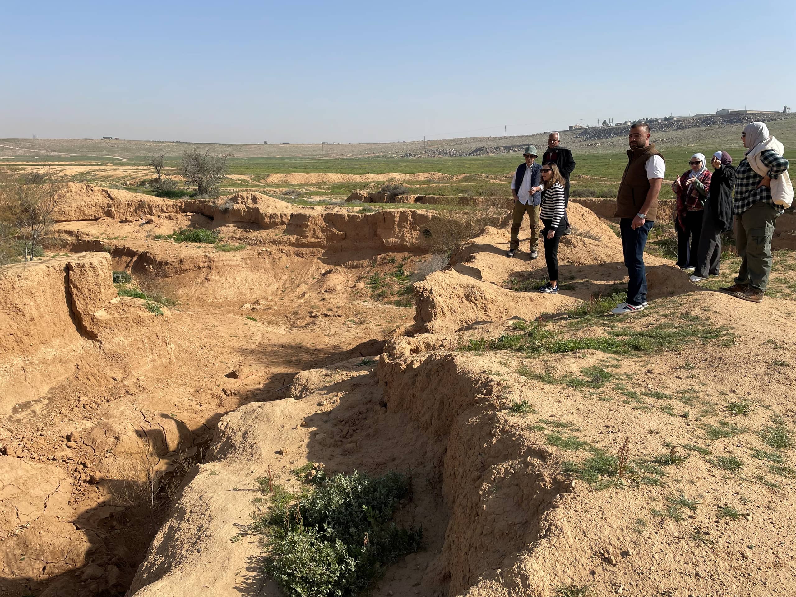 Eroded land on left side with group of people on right side