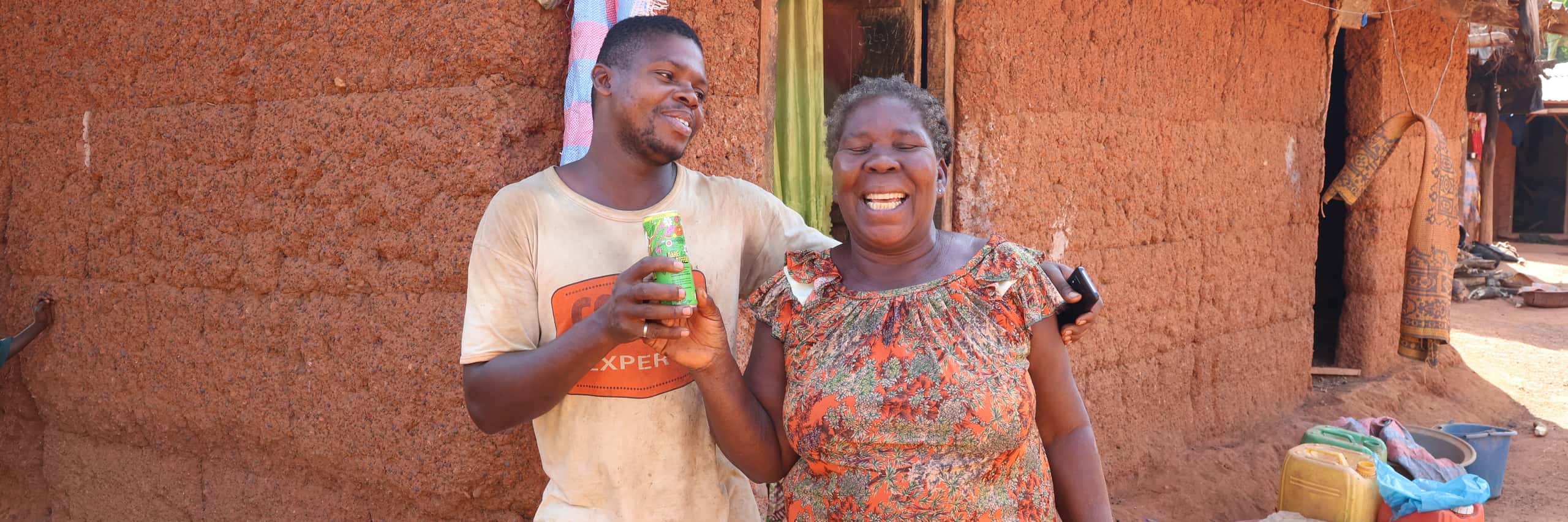 Cocoa farmers proudly showing a can with Kumasi juice.