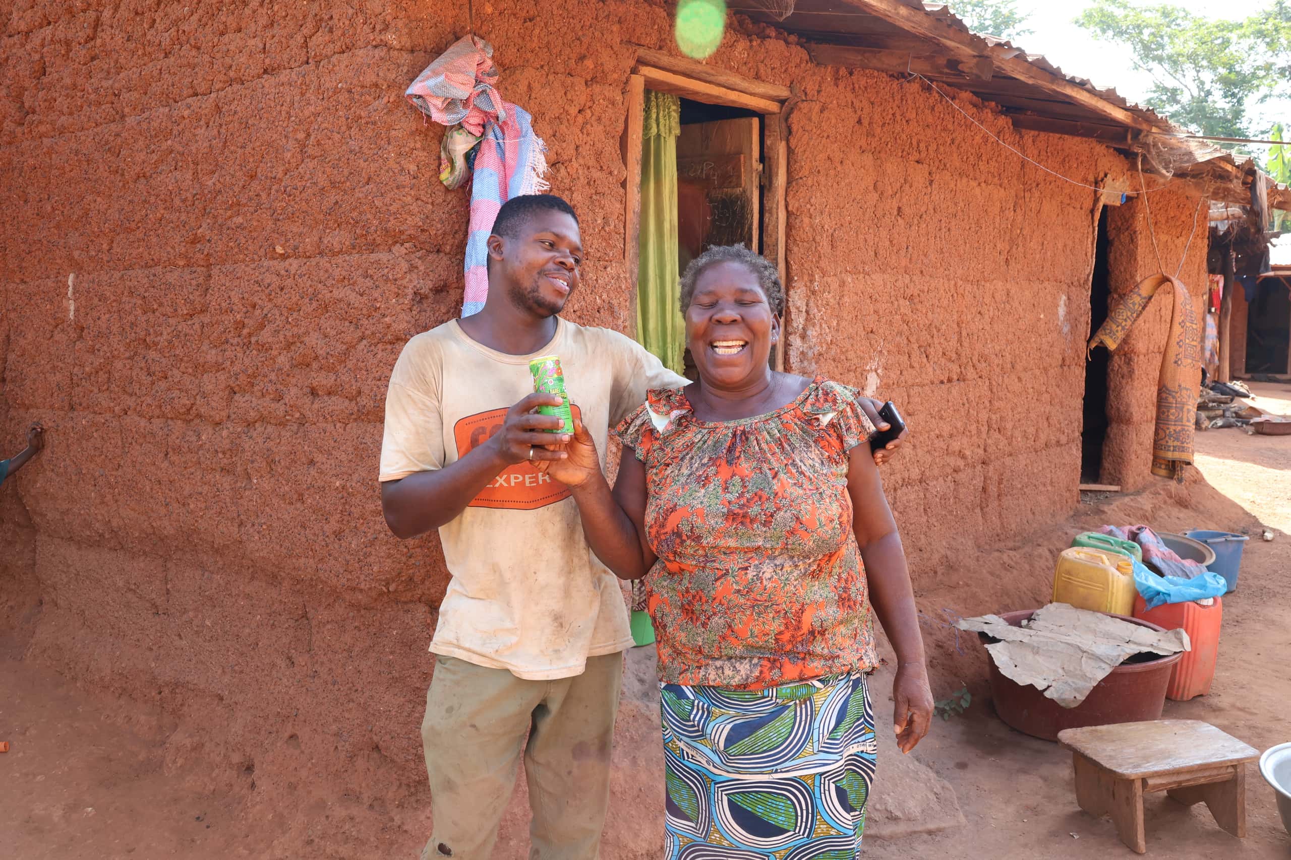 Cocoa farmers proudly showing a can with Kumasi juice.