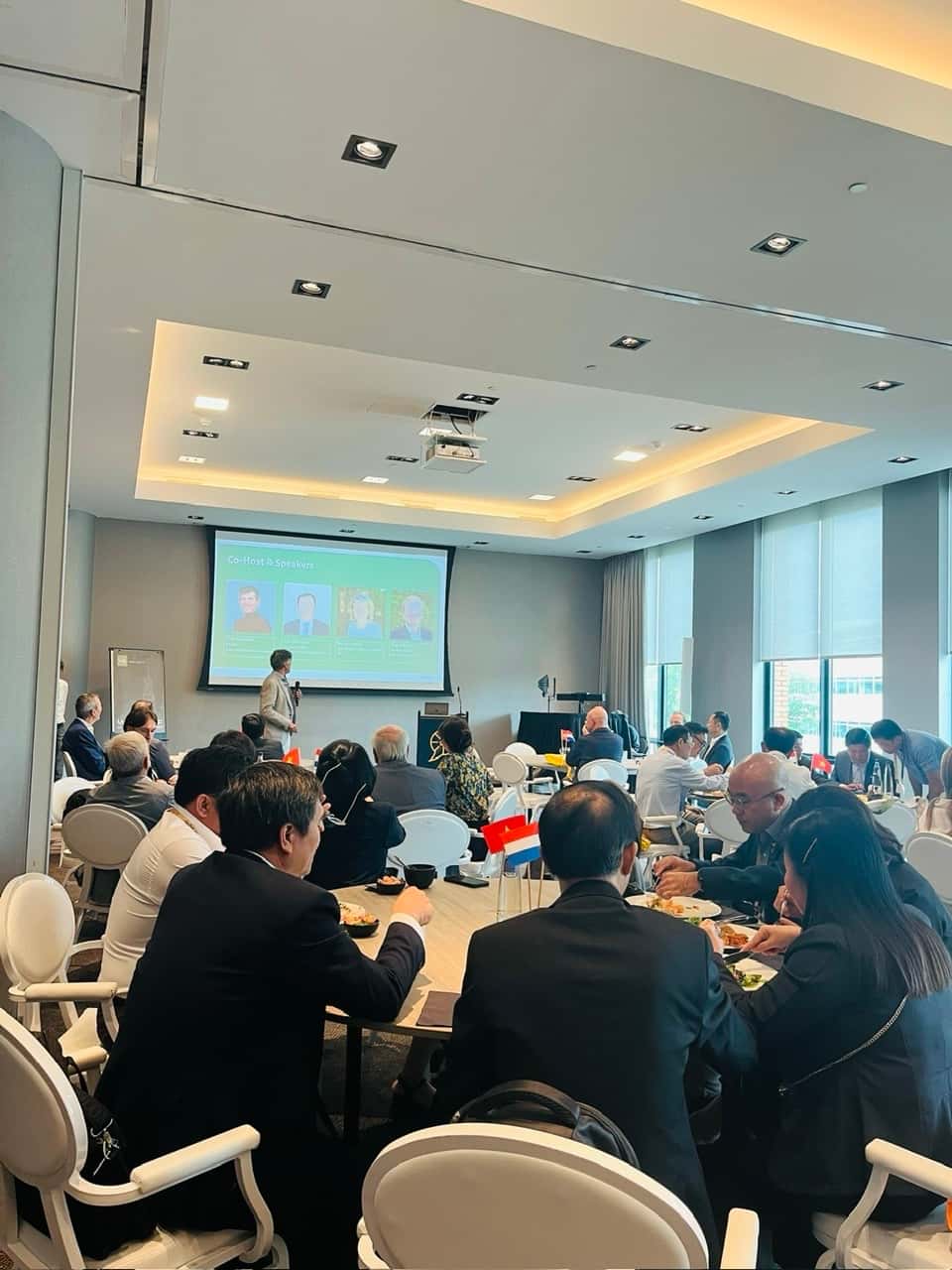 round table, 20 people in the room, discussing, 1 presentation