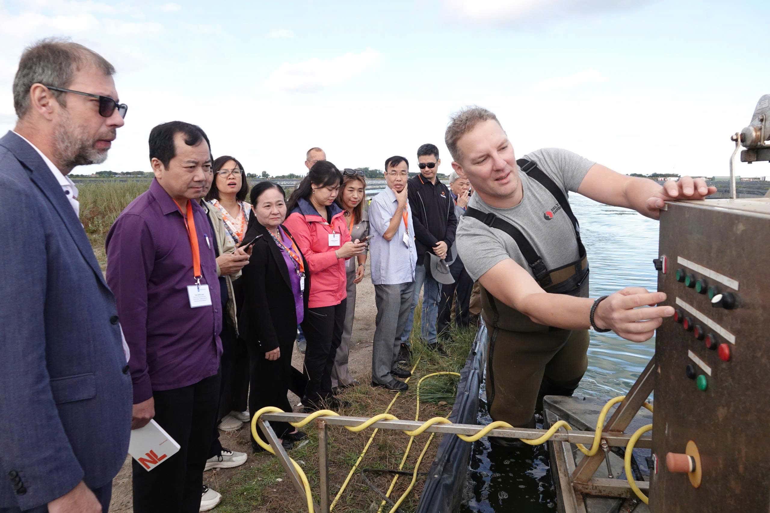1 man showing the machine to a group of 10 people outdoor