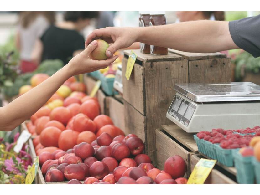 Klant betaalt aankoop fruit op markt