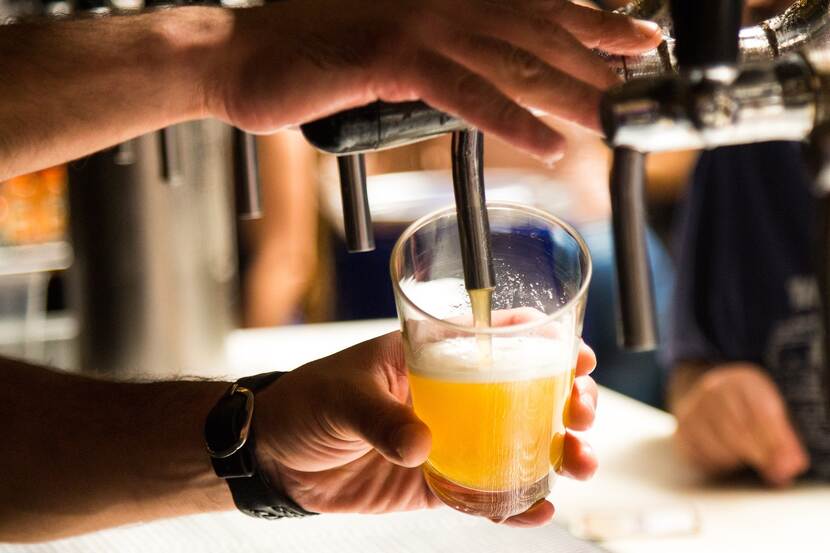 A bartender taps beer.
