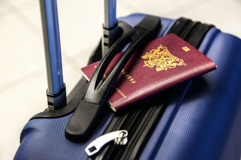 A passport placed on top of a suitcase.