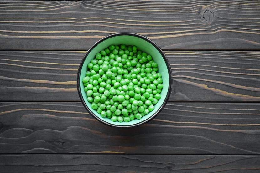 Peas in a pot on a wooden table