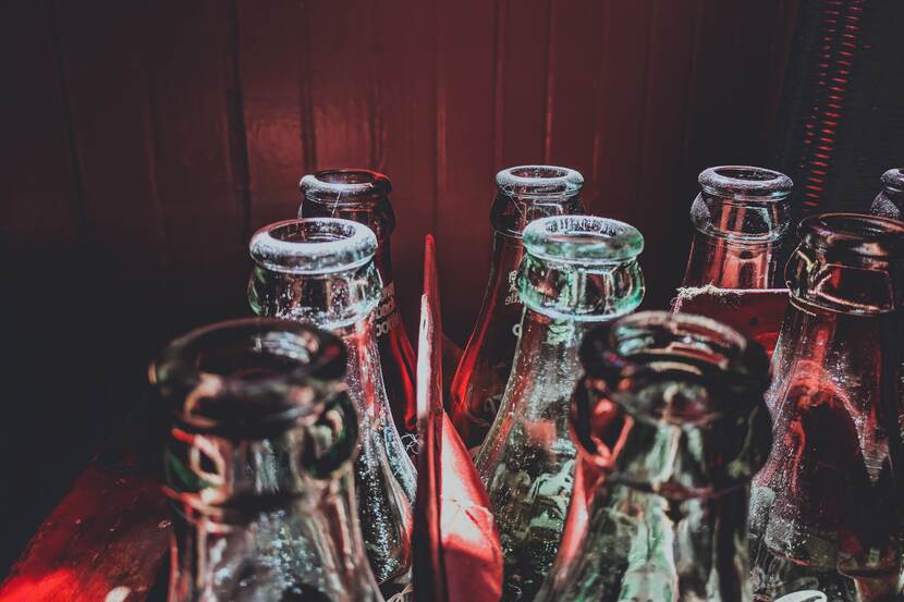 Close-up photo of empty soda bottles in a crate.