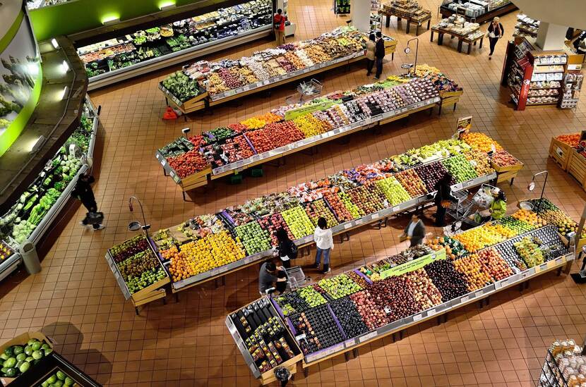 Picture of people buying fruits and vegetables at a supermarket.