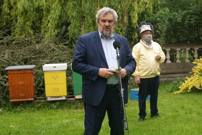 Polish Minister of Agriculture standing in front of hives having a press conference