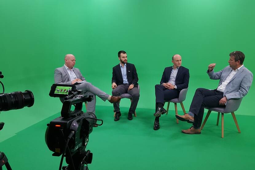 panel discussion in a green box with visible camera's