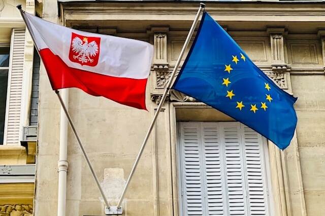 flags of Poland and European Union hanging on the wall of a builiding