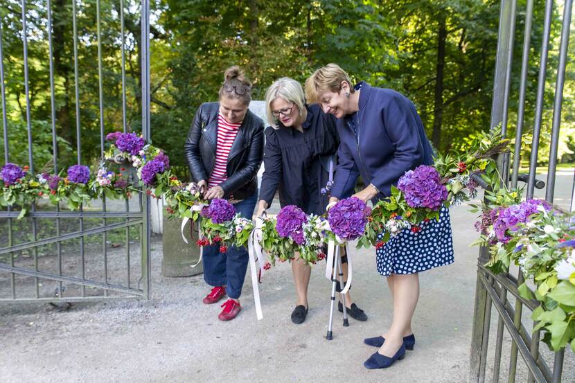 three ladies cutting the flower ribbon