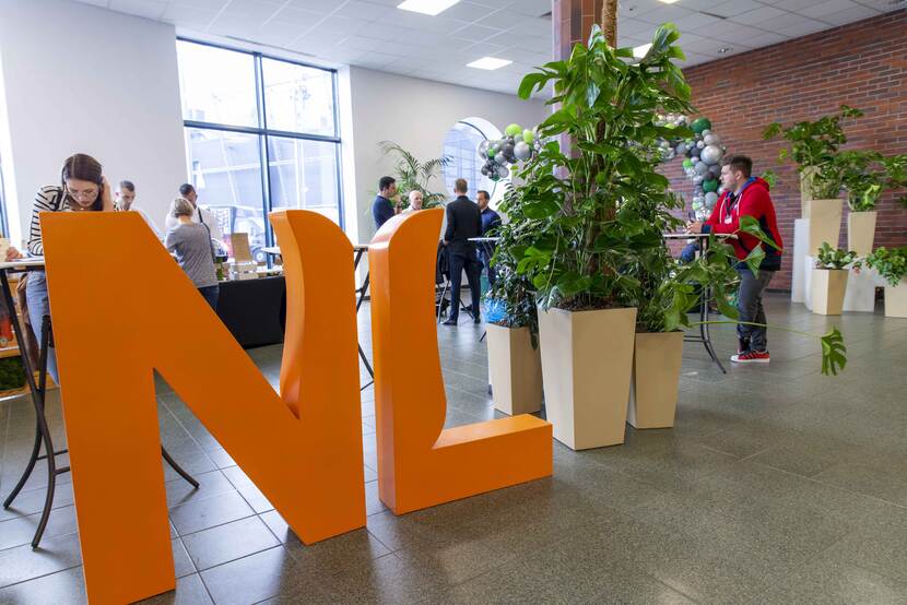 big orange NL letters with green plants in the background