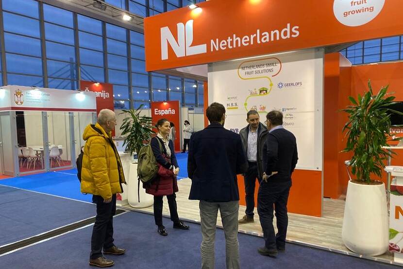 People talking in a circle at the Netherlands stand at the Agro Belgrade fair.