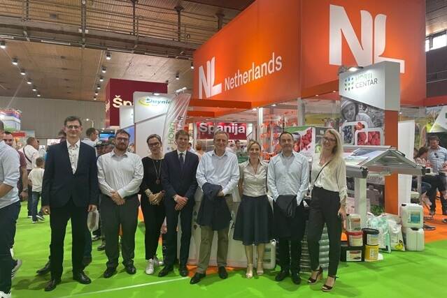 Netherlands Embassy colleagues standing in front of the Orange Pavilion at the Novi Sad Fair.