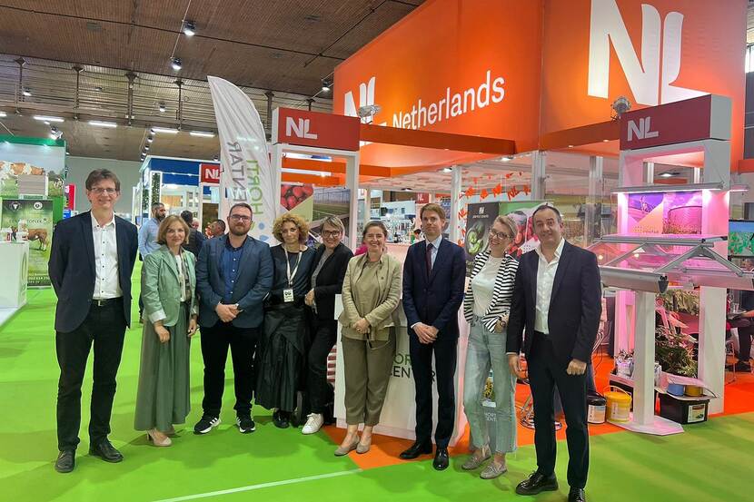 A photo of the Dutch embassy colleagues standing in front of the Orange Pavilion at the expo.