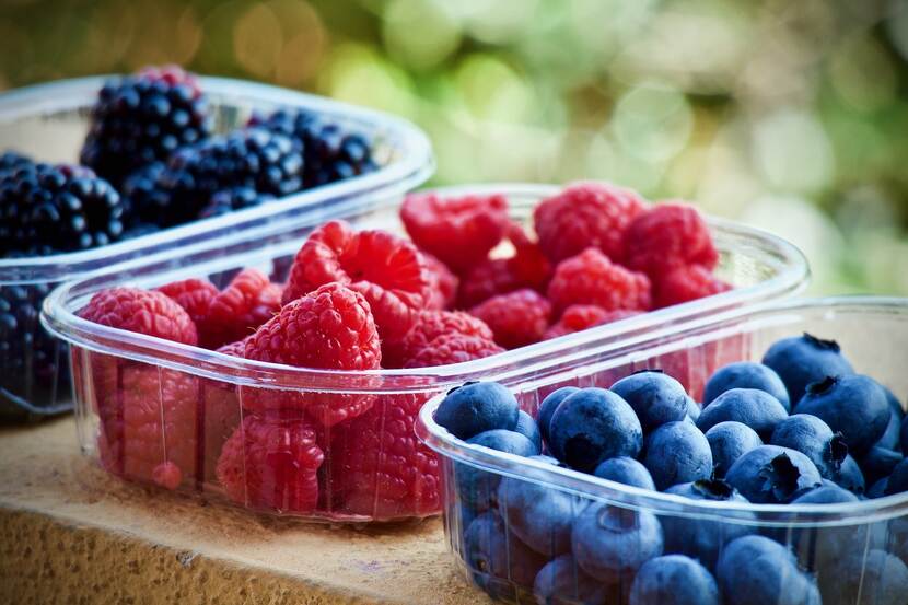 Berry fruits put into little plastic boxes.