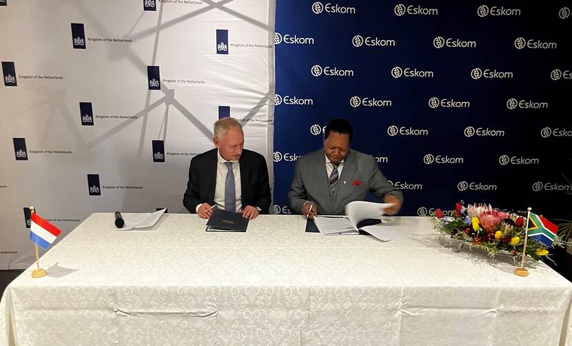 The Dutch Ambassador to South Africa is seated on the left of the Eskom chairman as they sign a letter of intent