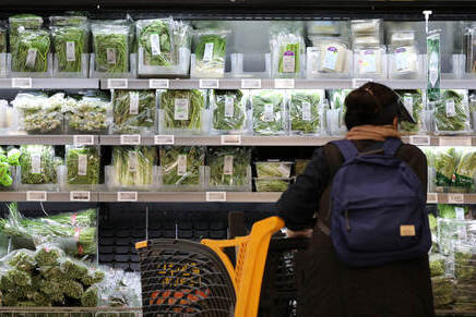 A customer shops for fresh produce at a local supermarket in Seoul.